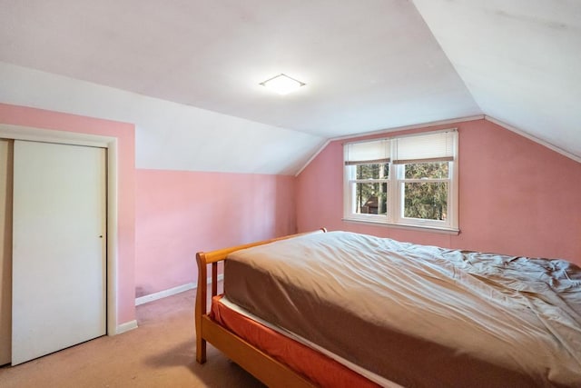 bedroom with baseboards, light carpet, and lofted ceiling