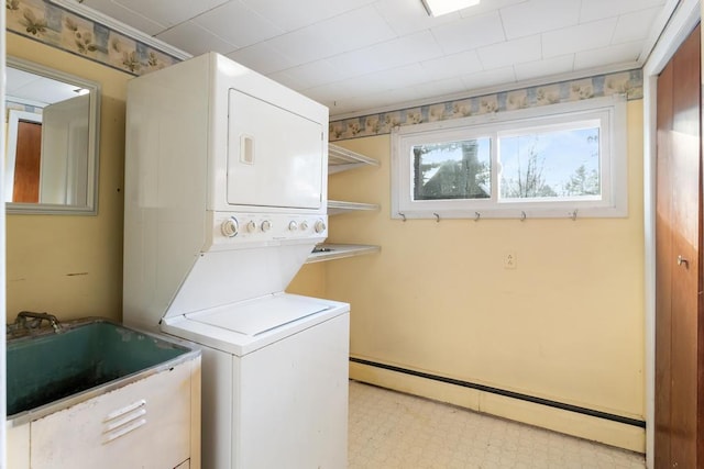 laundry room with stacked washer and dryer, a sink, a baseboard heating unit, light floors, and laundry area