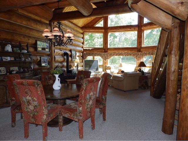 dining room with carpet floors, high vaulted ceiling, a wood stove, beamed ceiling, and a chandelier