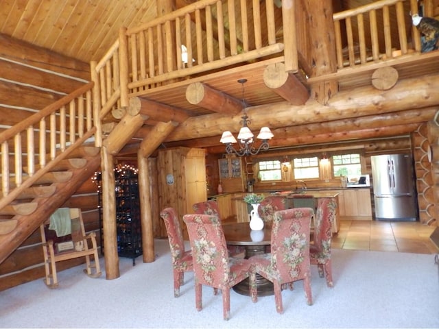 dining space with stairway, light tile patterned floors, a high ceiling, a notable chandelier, and rustic walls