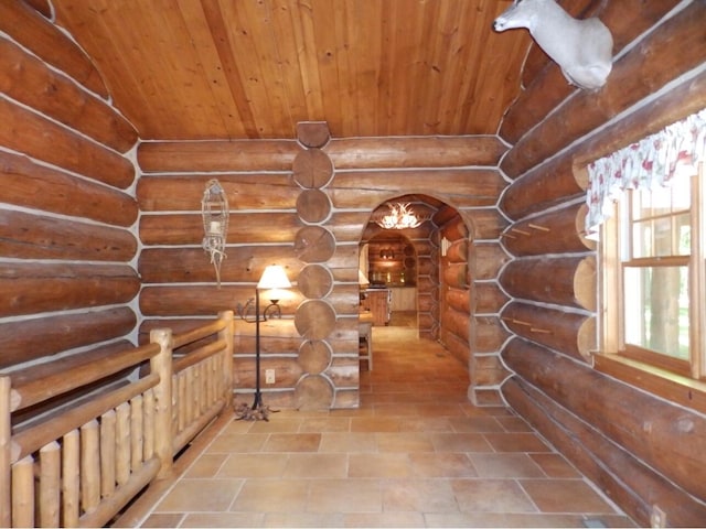 wine room featuring rustic walls, arched walkways, and wood ceiling