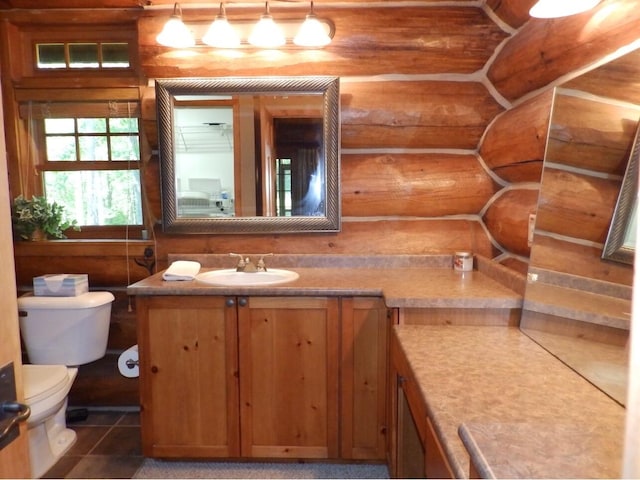 half bathroom with tile patterned flooring, toilet, log walls, and vanity