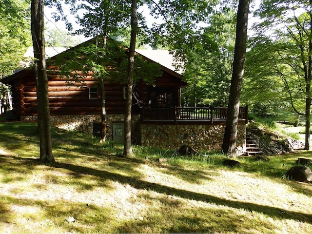 view of side of property featuring a wooden deck and log exterior