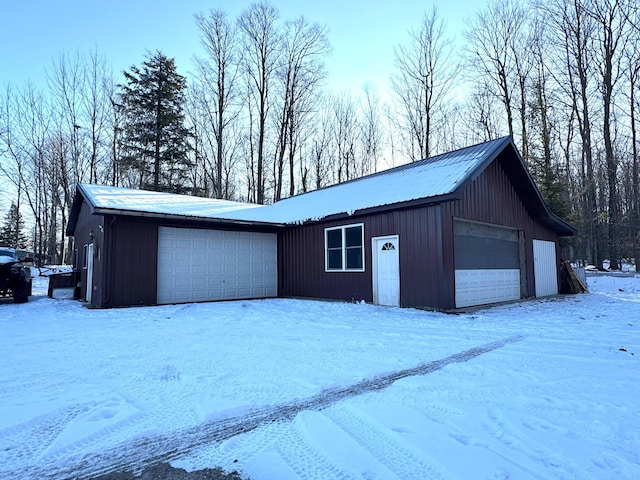 snow covered garage featuring a garage