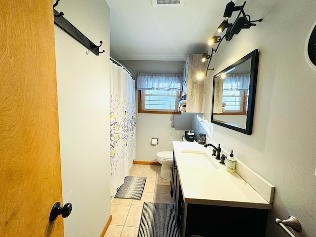 bathroom with vanity, baseboards, visible vents, tile patterned floors, and toilet