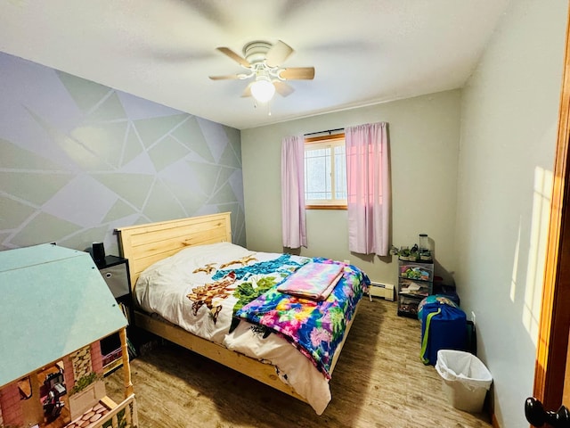 bedroom with baseboard heating, wood finished floors, and a ceiling fan