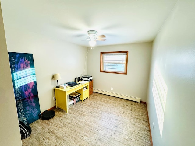 office space with a baseboard heating unit, baseboards, a ceiling fan, and light wood finished floors