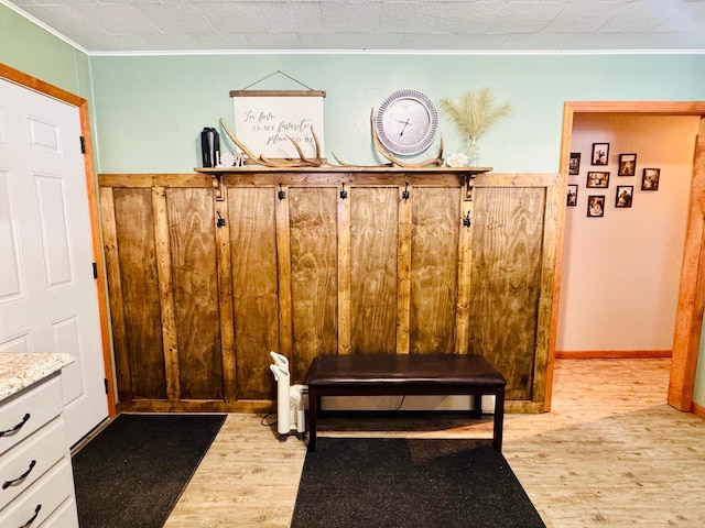 mudroom with baseboards, light wood-type flooring, and ornamental molding