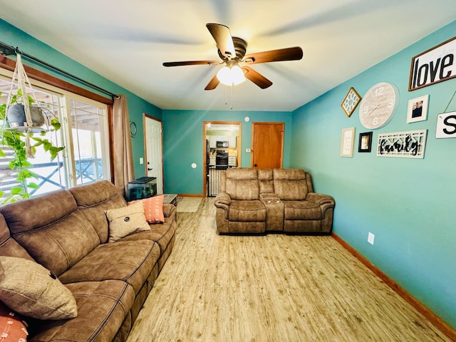 living room featuring a ceiling fan, wood finished floors, and baseboards