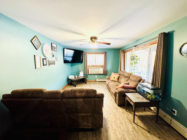 living area featuring baseboard heating, a baseboard heating unit, baseboards, and wood finished floors