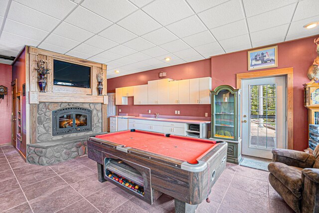 5560 Chestnut Dr, Cheboygan, MI 49721 - game room featuring pool table, a stone fireplace, a sink, a drop ceiling, and light tile patterned floors