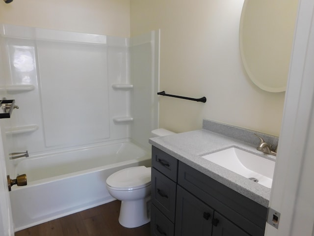 bathroom with toilet, wood finished floors, vanity, and shower / tub combination