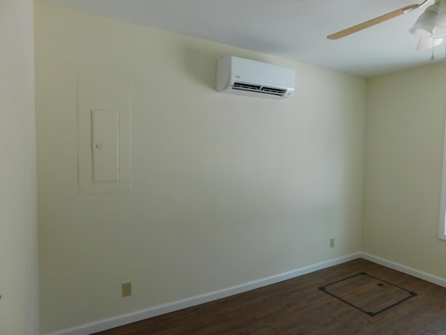 spare room with ceiling fan, baseboards, dark wood finished floors, a wall unit AC, and electric panel