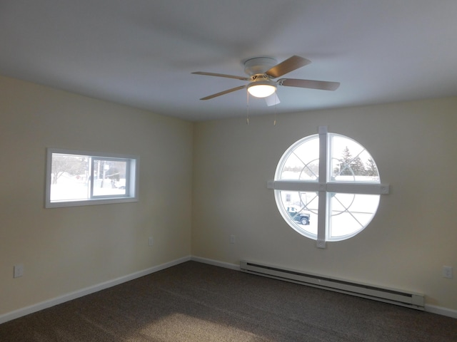 empty room with dark carpet, a healthy amount of sunlight, baseboards, and baseboard heating