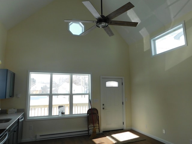 foyer entrance with baseboard heating, plenty of natural light, high vaulted ceiling, and ceiling fan