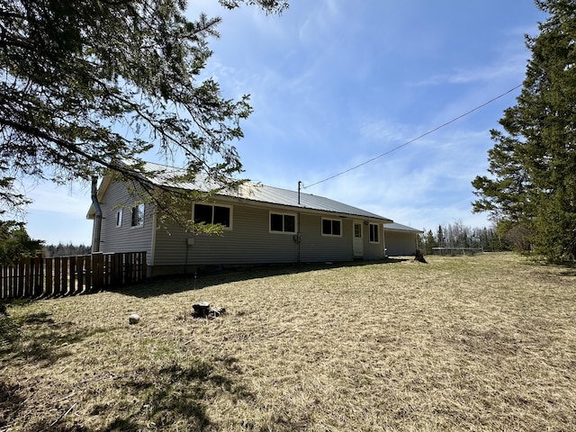 6348 Zolner Rd, Cheboygan, MI 49721 - rear view of house featuring fence, a yard, and metal roof