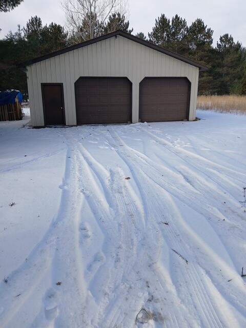 snow covered garage featuring a garage