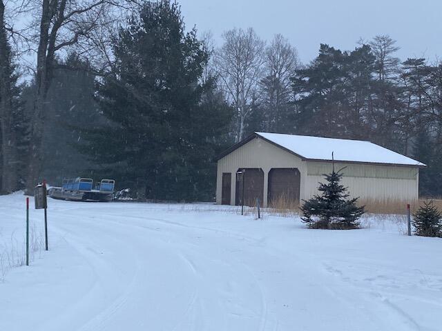 snow covered structure with an outbuilding