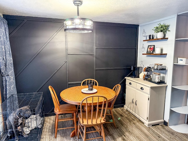 dining area with a textured ceiling and wood finished floors