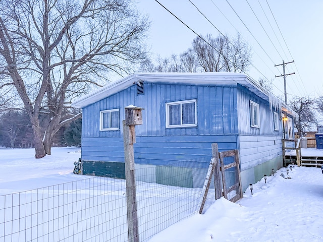 view of snow covered exterior with board and batten siding