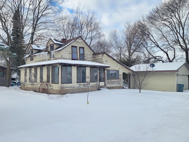 view of front of home with a garage and a sunroom