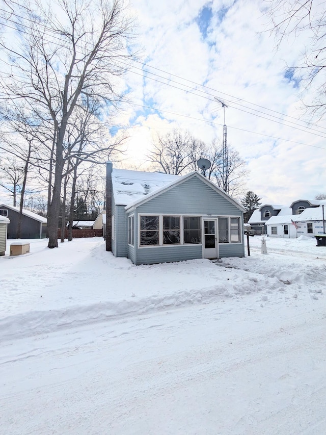 view of front of property with central AC, a chimney, and a sunroom