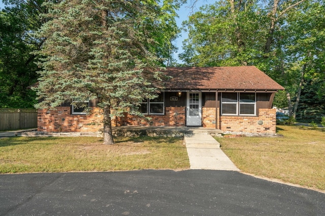 4878 S Straits Hwy, Indian River, MI 49749 - ranch-style home with brick siding, a front yard, and fence