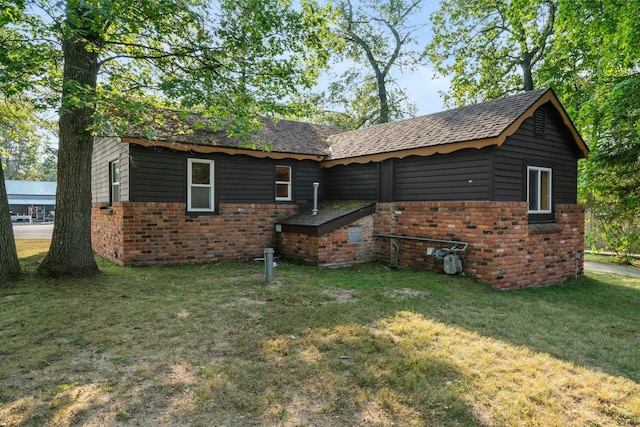 4878 S Straits Hwy, Indian River, MI 49749 - rear view of house with a yard and brick siding