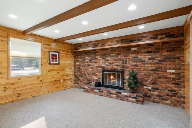 4878 S Straits Hwy, Indian River, MI 49749 - unfurnished living room with a brick fireplace, beamed ceiling, wood walls, carpet floors, and recessed lighting