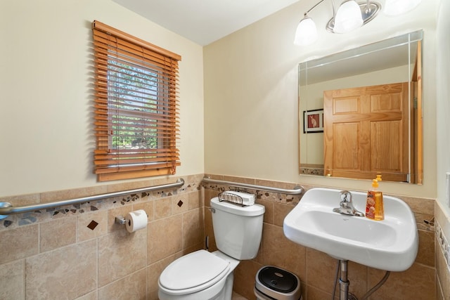 4878 S Straits Hwy, Indian River, MI 49749 - half bathroom with a sink, toilet, tile walls, and wainscoting