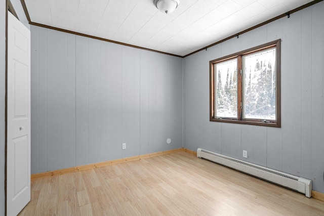 2862 Arlene, Indian River, MI 49749 - empty room featuring a baseboard heating unit, wood finished floors, crown molding, and baseboards