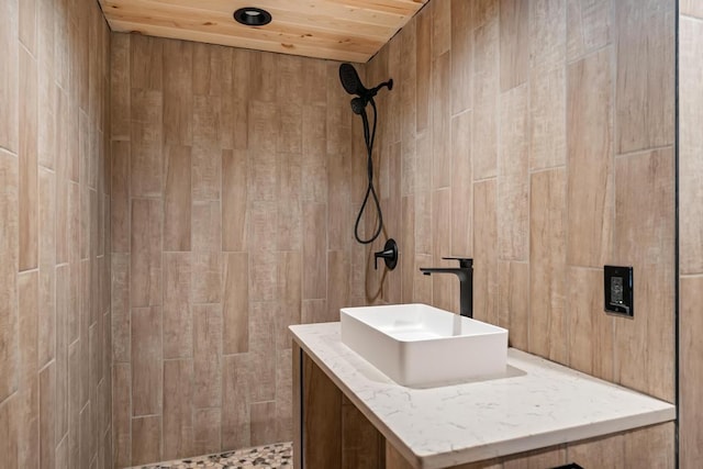 full bath with tiled shower, wooden ceiling, and vanity