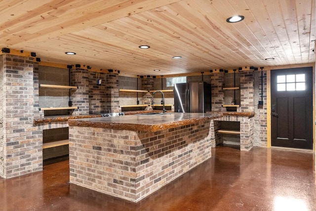 bar with a sink, concrete floors, wood ceiling, and freestanding refrigerator