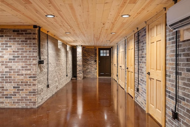 hallway featuring brick wall, finished concrete flooring, an AC wall unit, recessed lighting, and wooden ceiling