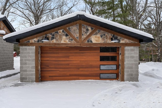 snow covered garage with a garage