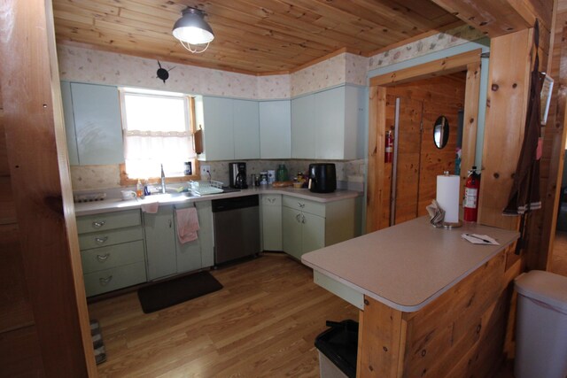 kitchen featuring light countertops, wooden ceiling, a peninsula, stainless steel dishwasher, and a sink