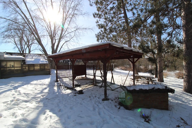 yard covered in snow with a gazebo and a detached carport