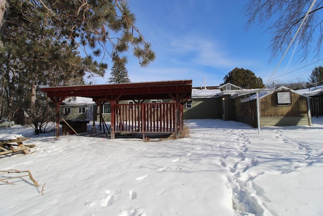 view of snow covered back of property