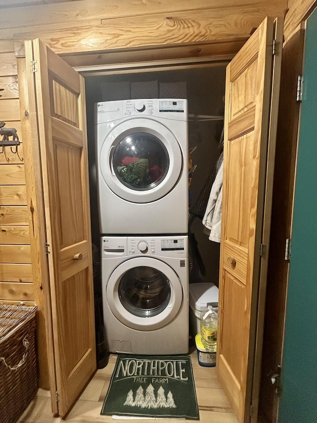 laundry room featuring stacked washer / drying machine and laundry area