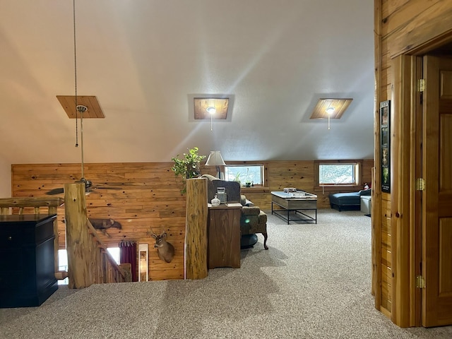 carpeted office with vaulted ceiling and wood walls