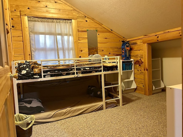 bedroom with wood walls, a textured ceiling, carpet, and vaulted ceiling