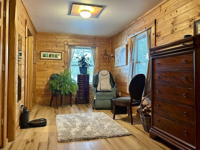 sitting room featuring wood finished floors, a healthy amount of sunlight, and a textured ceiling