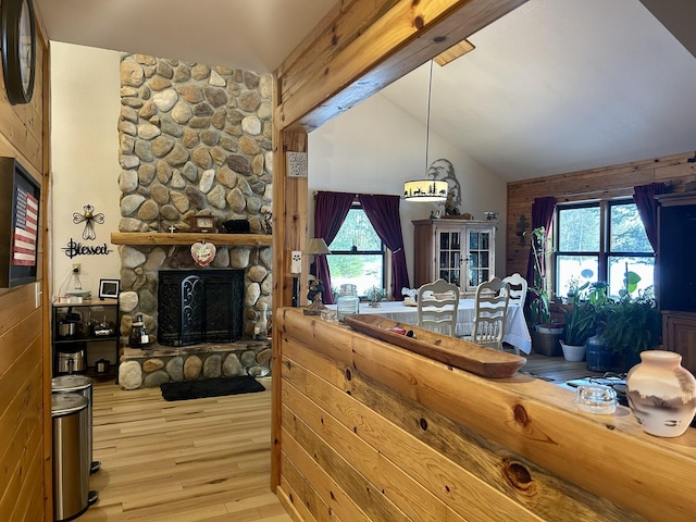 interior space with wood finished floors, high vaulted ceiling, a fireplace, beamed ceiling, and open floor plan