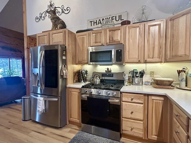 kitchen with light wood finished floors, light brown cabinets, stainless steel appliances, and light countertops