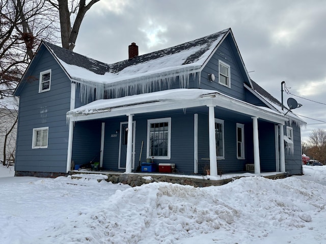 view of front facade with a porch and a chimney