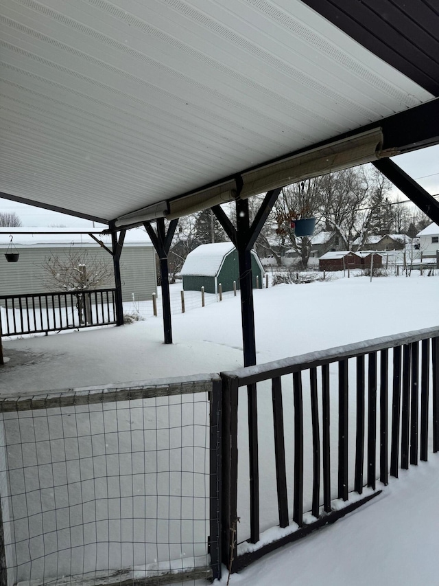 snow covered deck featuring fence