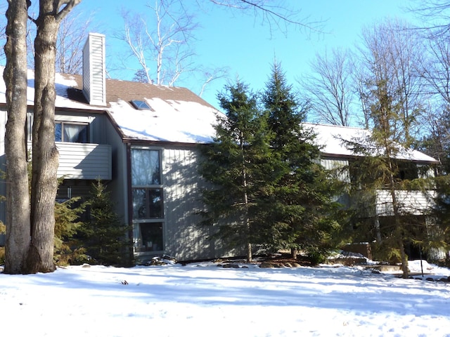 view of snowy exterior with a chimney