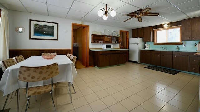 kitchen with wainscoting, white appliances, light countertops, and open shelves