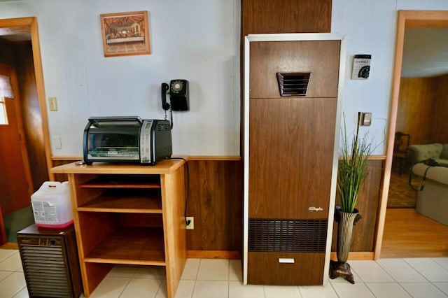 interior space with tile patterned floors and wood walls