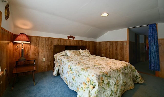 bedroom with wainscoting, carpet flooring, wood walls, and vaulted ceiling